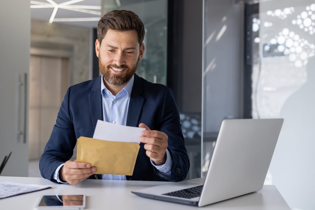direct mail smiling businessman opening direct mail